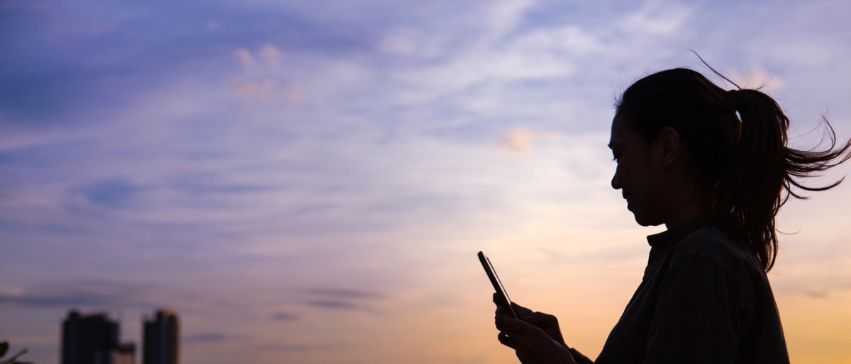 Silhouette of a woman using mobile phone