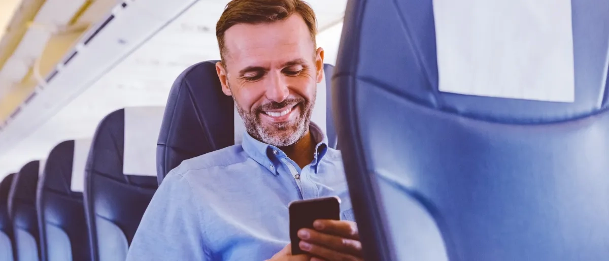 Image of a person using mobile phone inside an airplane