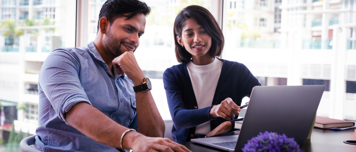 Two people working in front of a laptop