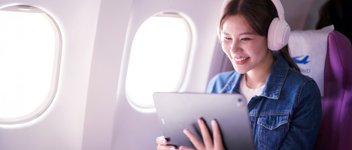 Image of a person using a tablet in an airplane.