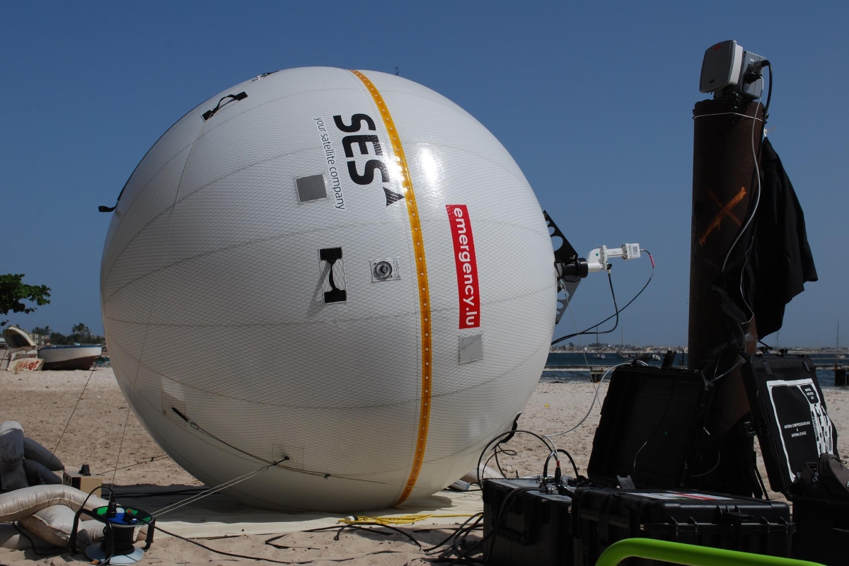 Inflatable satellite terminal surrounded by equipment on a beach 