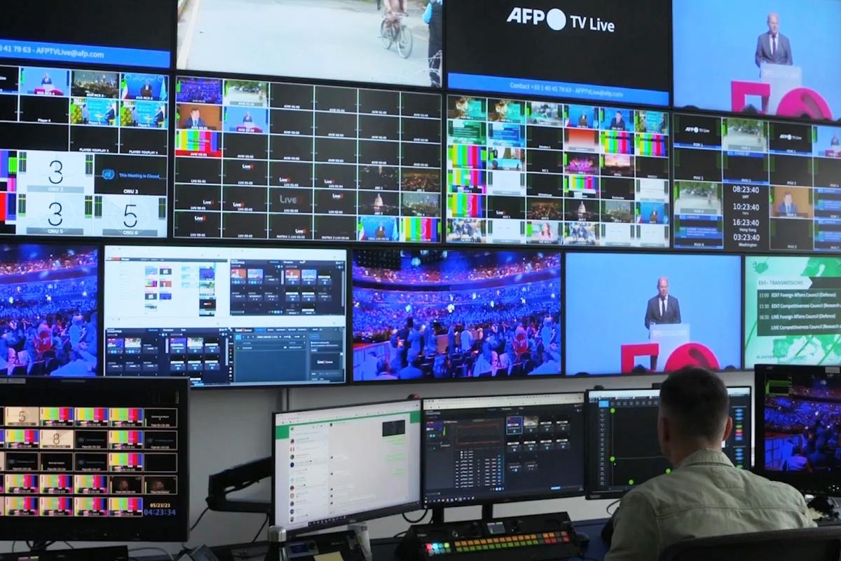 Image of a operator monitoring multiple broadcast feeds in a control room.