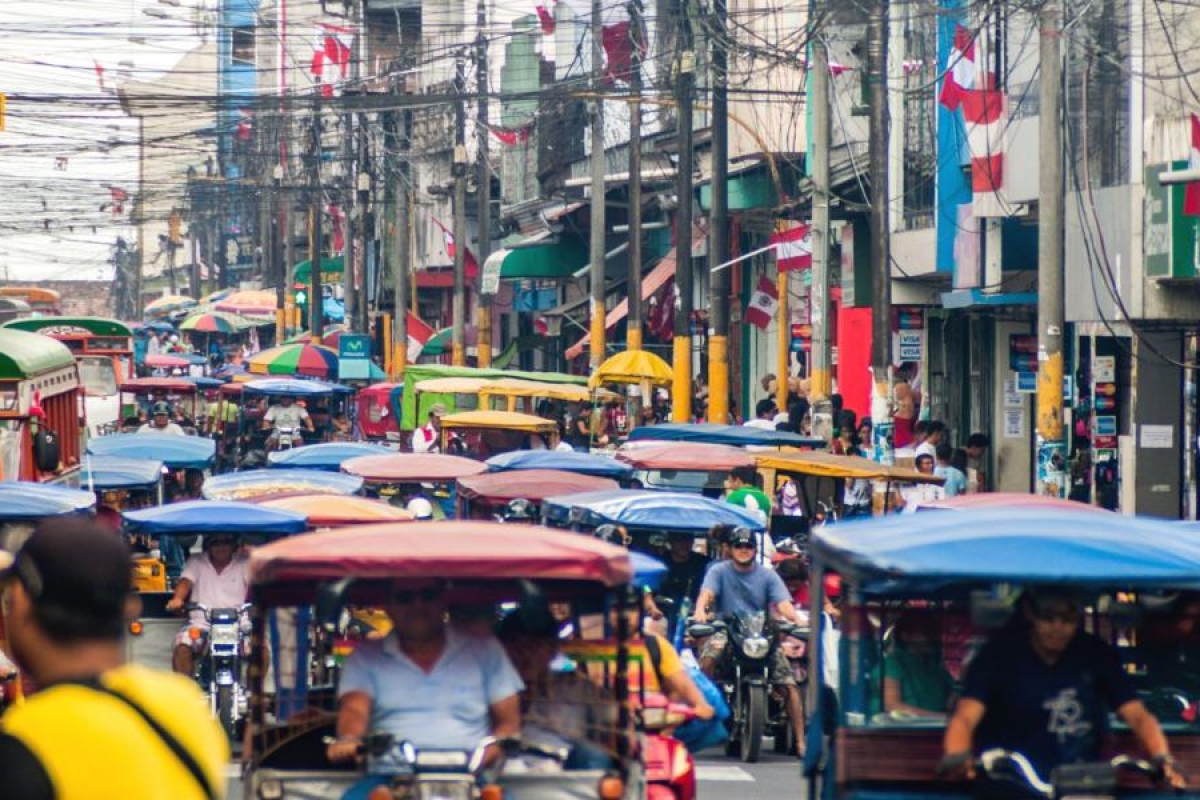 Image of a busy street packed with vehicles and people.