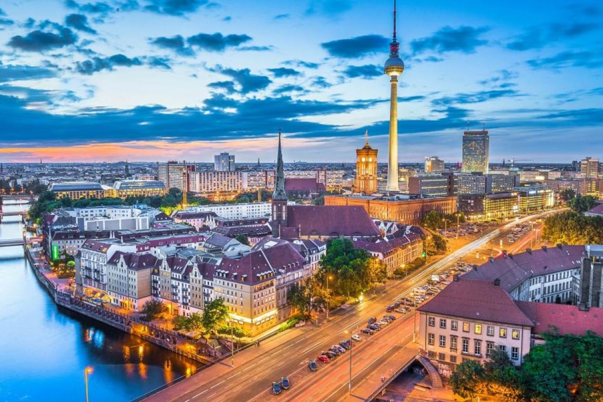 Cityscape at dusk featuring the TV Tower and illuminated streets.