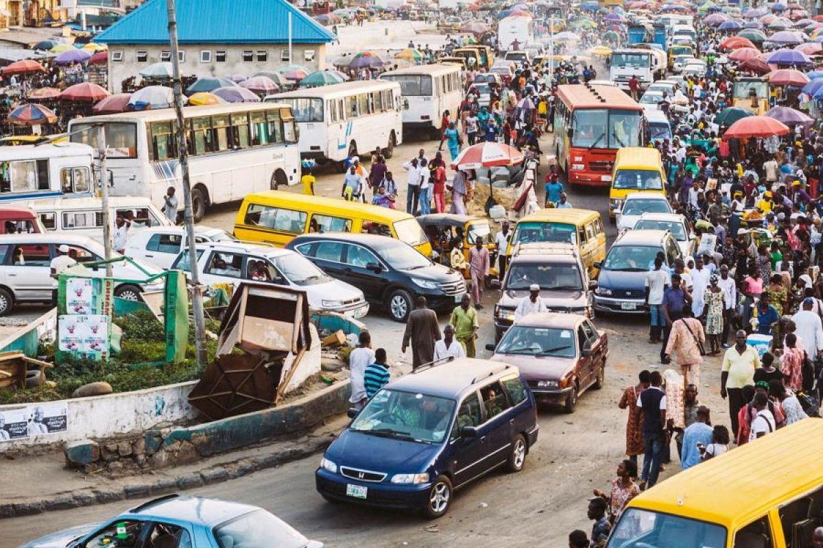Image of a busy street packed with cars, buses and people.