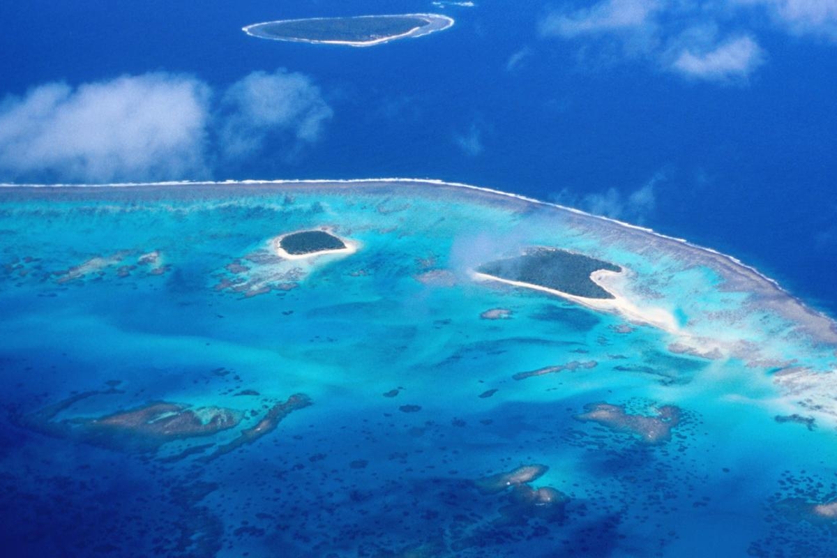 Image of aerial view of a turquoise atoll surrounded by deep blue ocean.