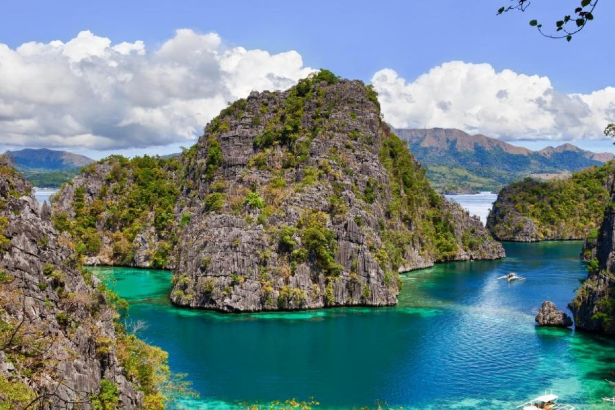 Image of turquoise lagoon surrounded by rocky green island.