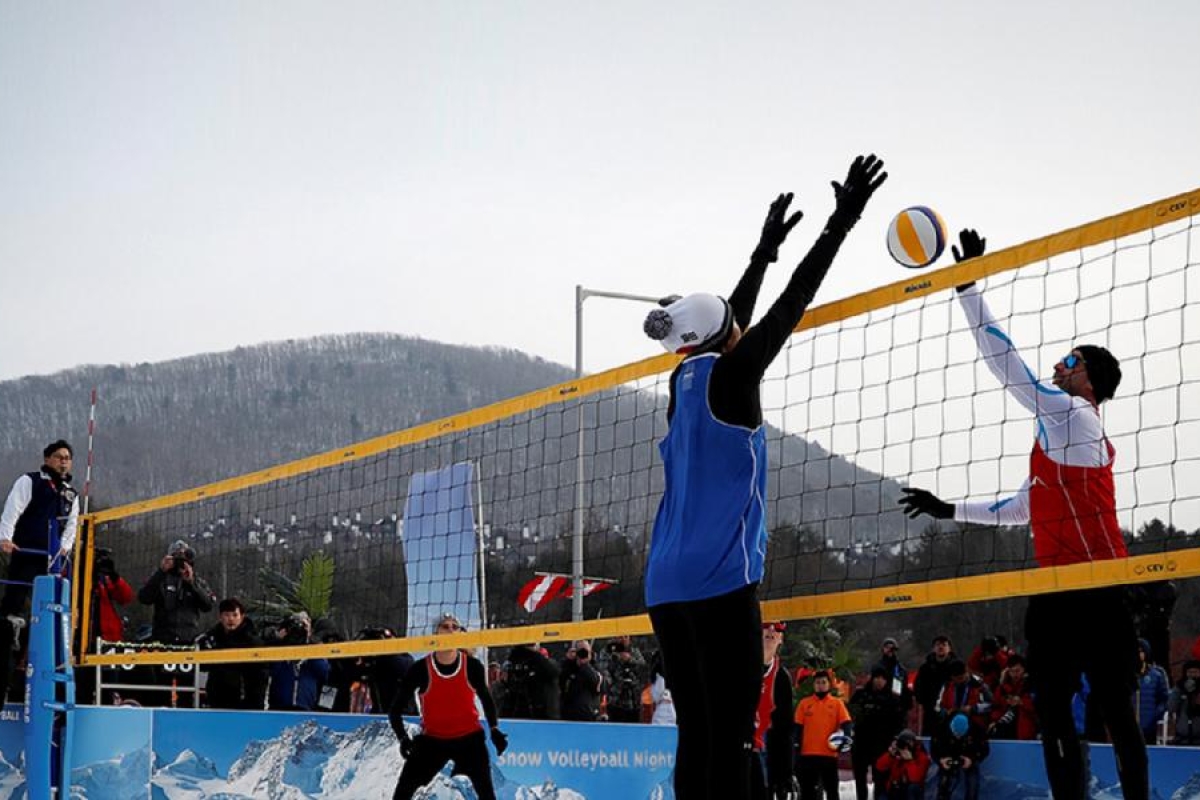 Image of an outdoor volleyball match played on a snowy region.