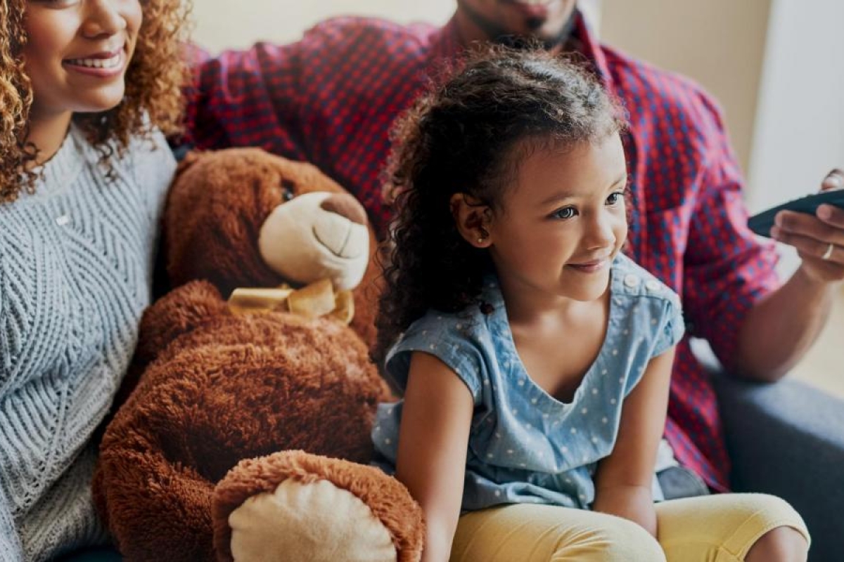 Image of a family sitting on a couch watching TV