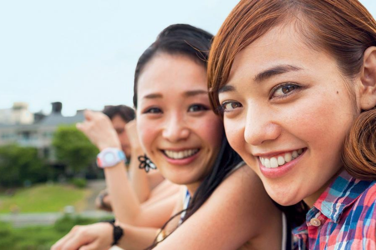 Image of two people clicking a selfie outdoors.