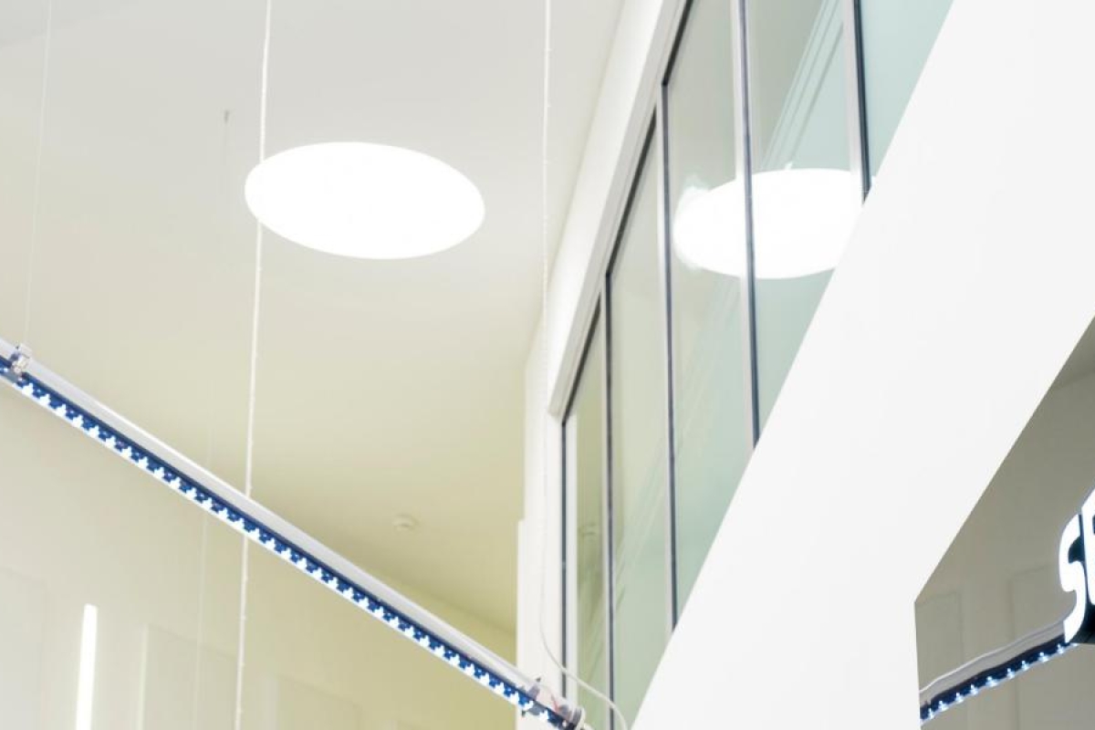 Image of interior view of a modern SES office with bright lighting and glass panels.