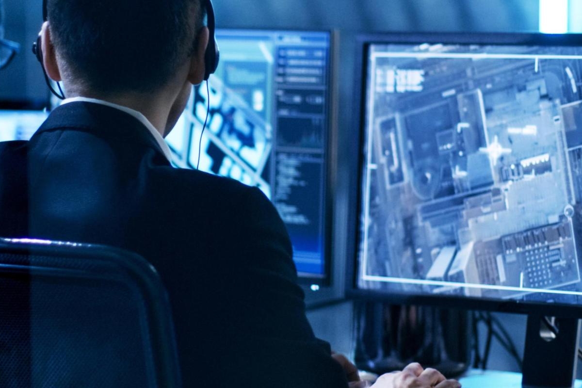 Image of two people reviewing satellite imagery on multiple monitors.