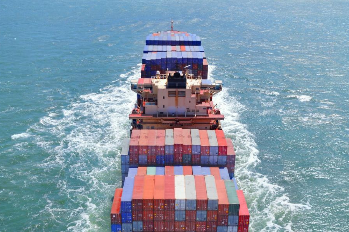 Image of a cargo ship carrying goods sailing in the sea.