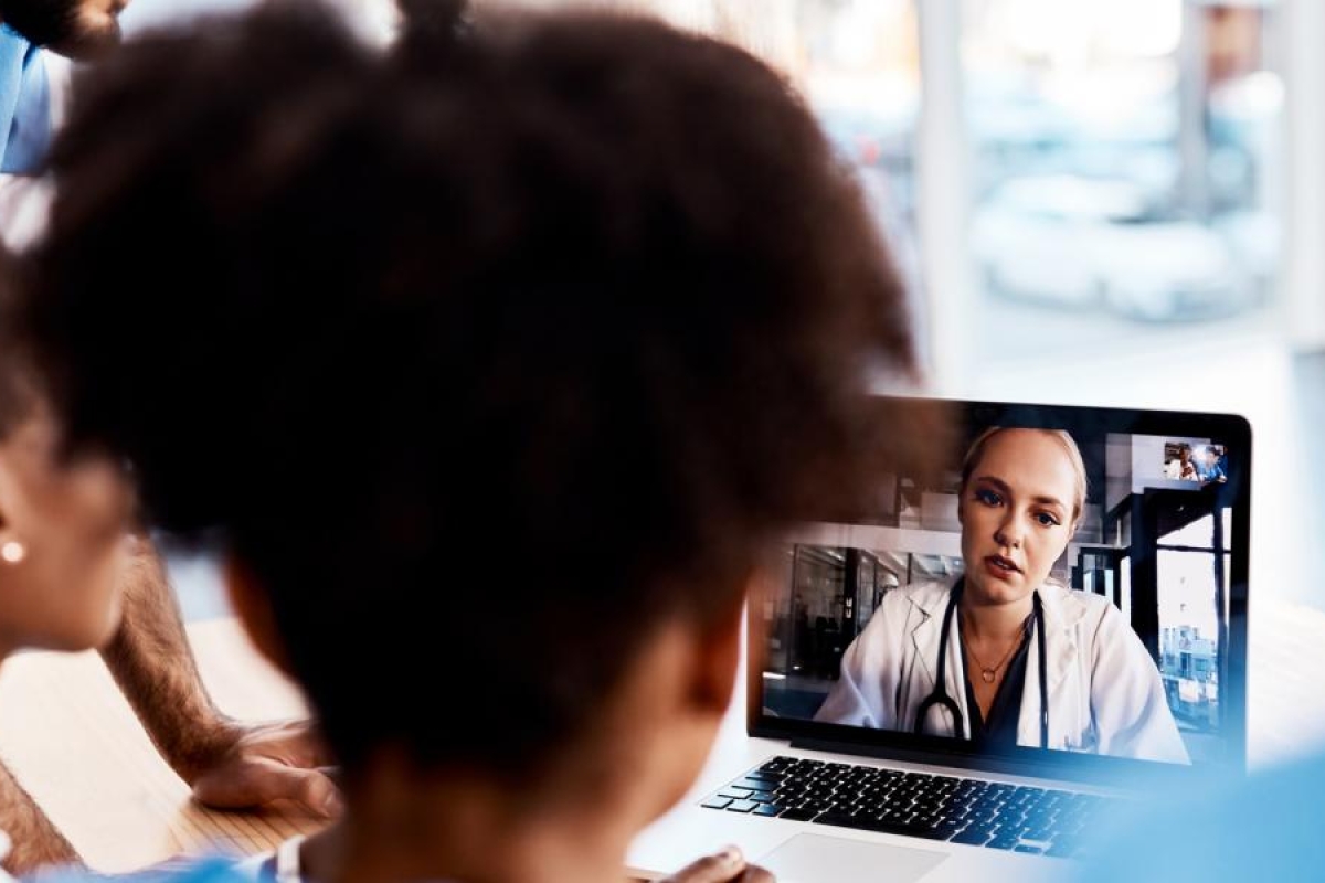Image of medical professionals talking to a doctor via laptop.