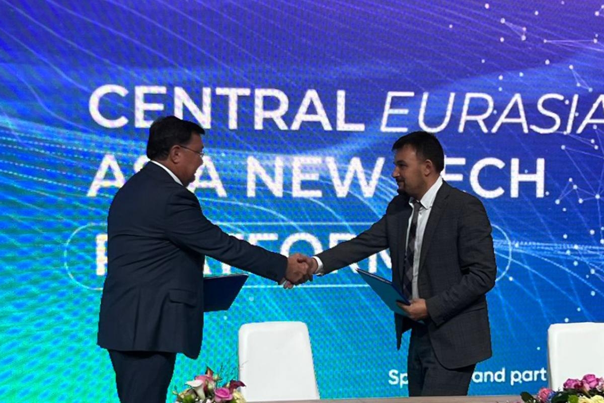 Image of two representatives shaking hands onstage at a Central Eurasia technology forum