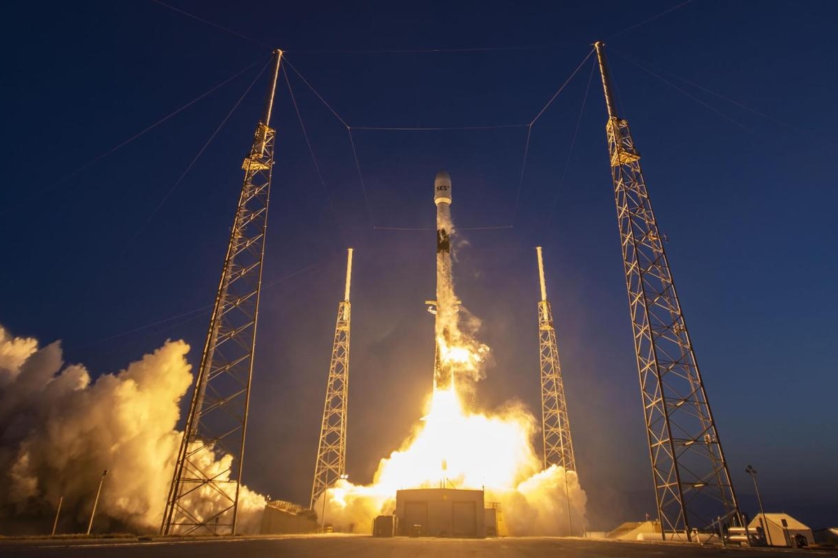 Image of a rocket launching at night with support towers illuminated.