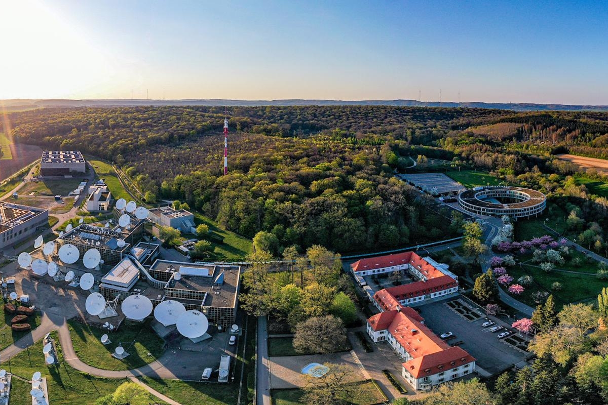 Image of Aerial view of SES Betzdorf site with satellite dishes and forest surrounding it.