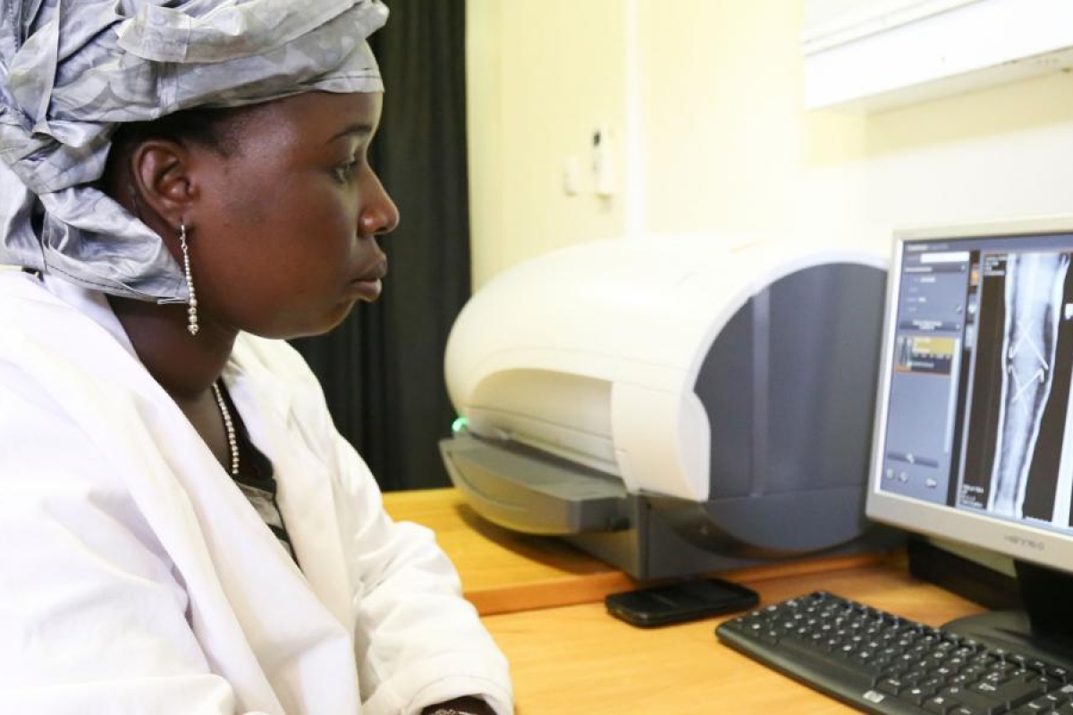 Image of medical professional reviewing leg X‑ray images on a computer.