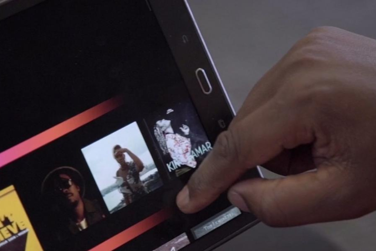 Image of a person swiping on tablet showing different shows