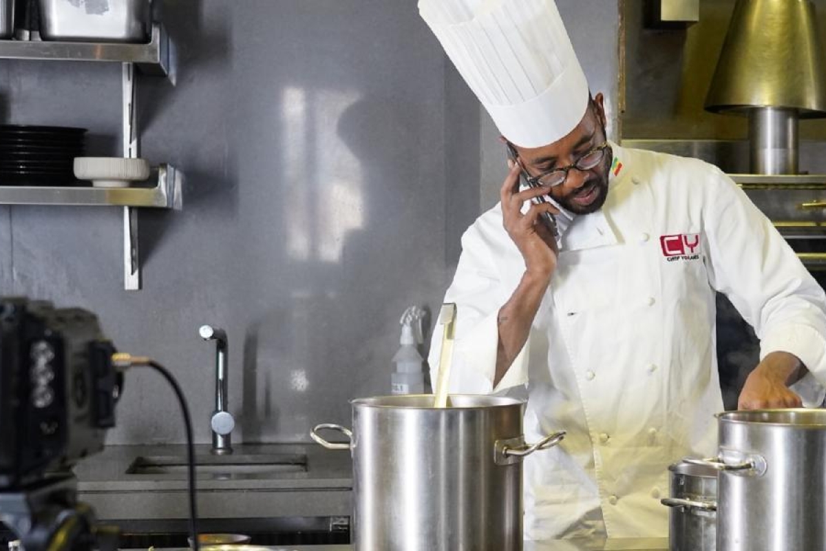 Image of a chef working while talking on the phone
