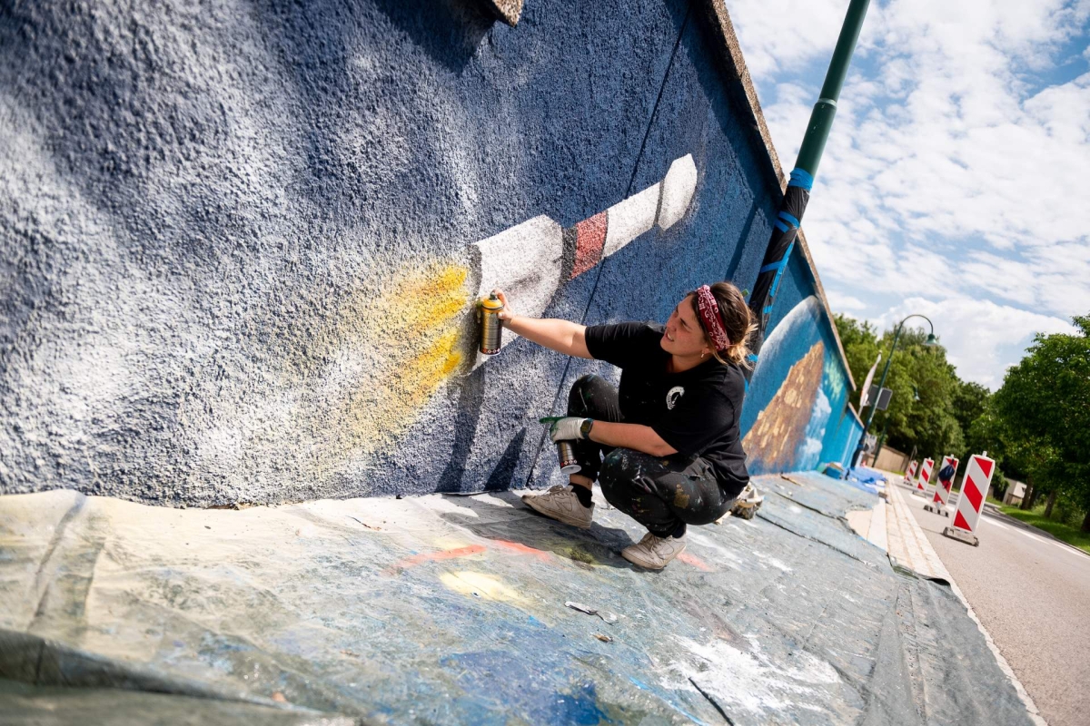 person painting rocket with paint spray