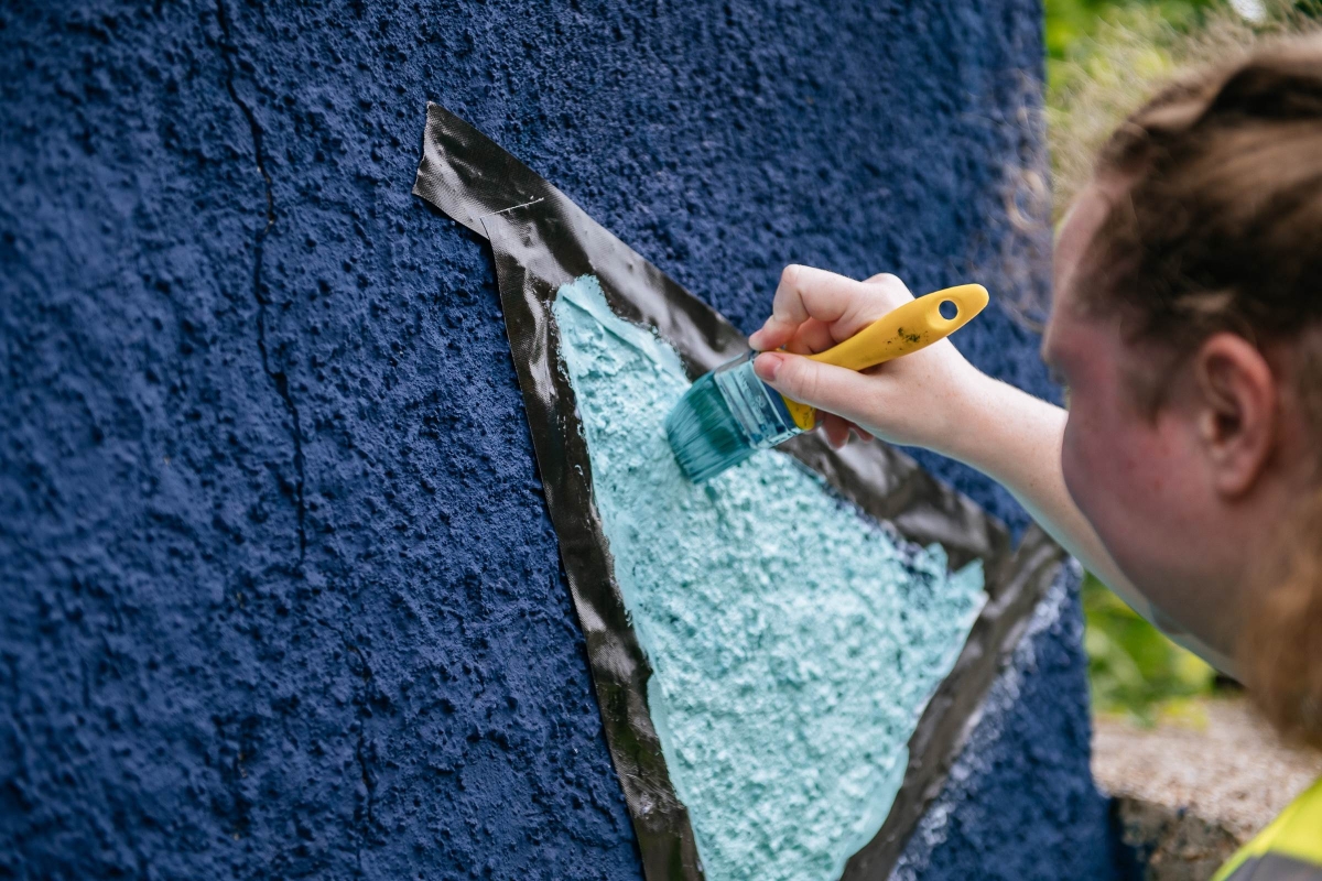 close up - person painting on mural
