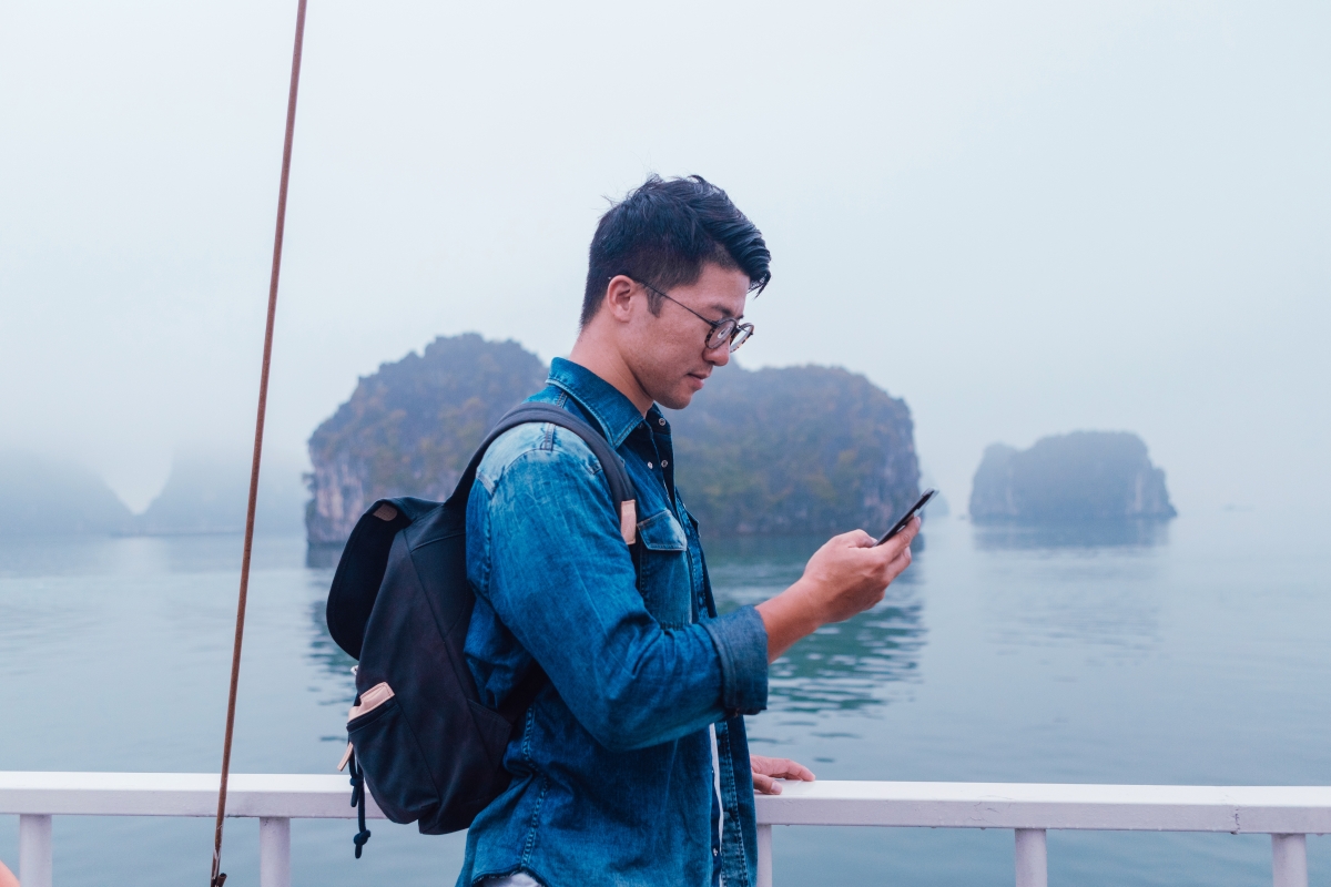Image of a Person using a phone on a ship.