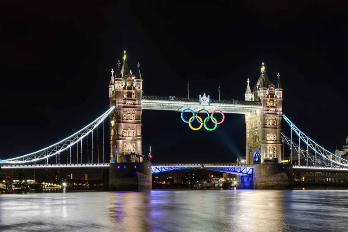 Image of Tower Bridge at night featuring glowing Olympic rings.