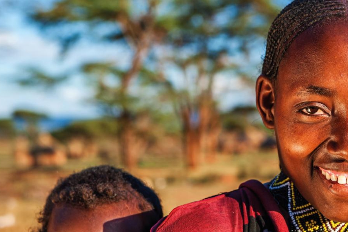 Portrait of a person outdoors with trees and rural landscape.