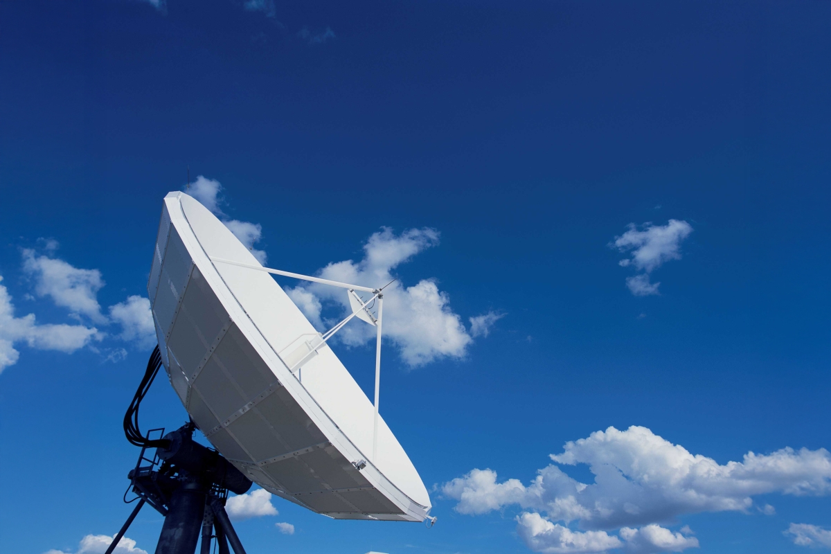 Image of an antenna dish setup with clouds in the background