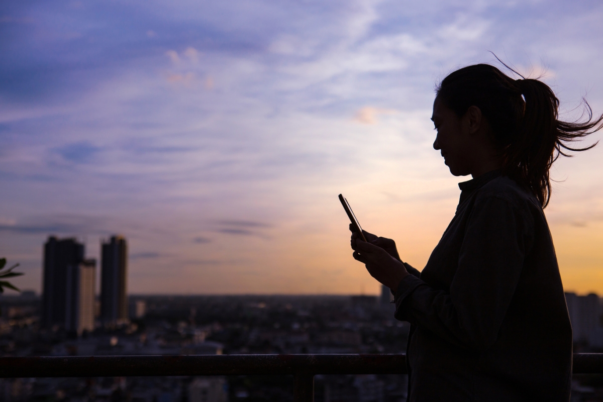 Silhouette of a woman using mobile phone