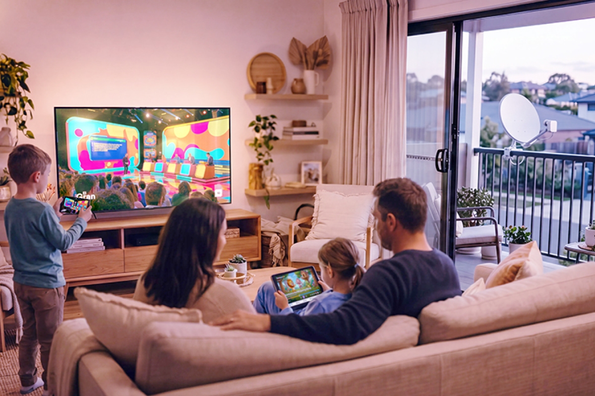Family sitting on the couch watching television