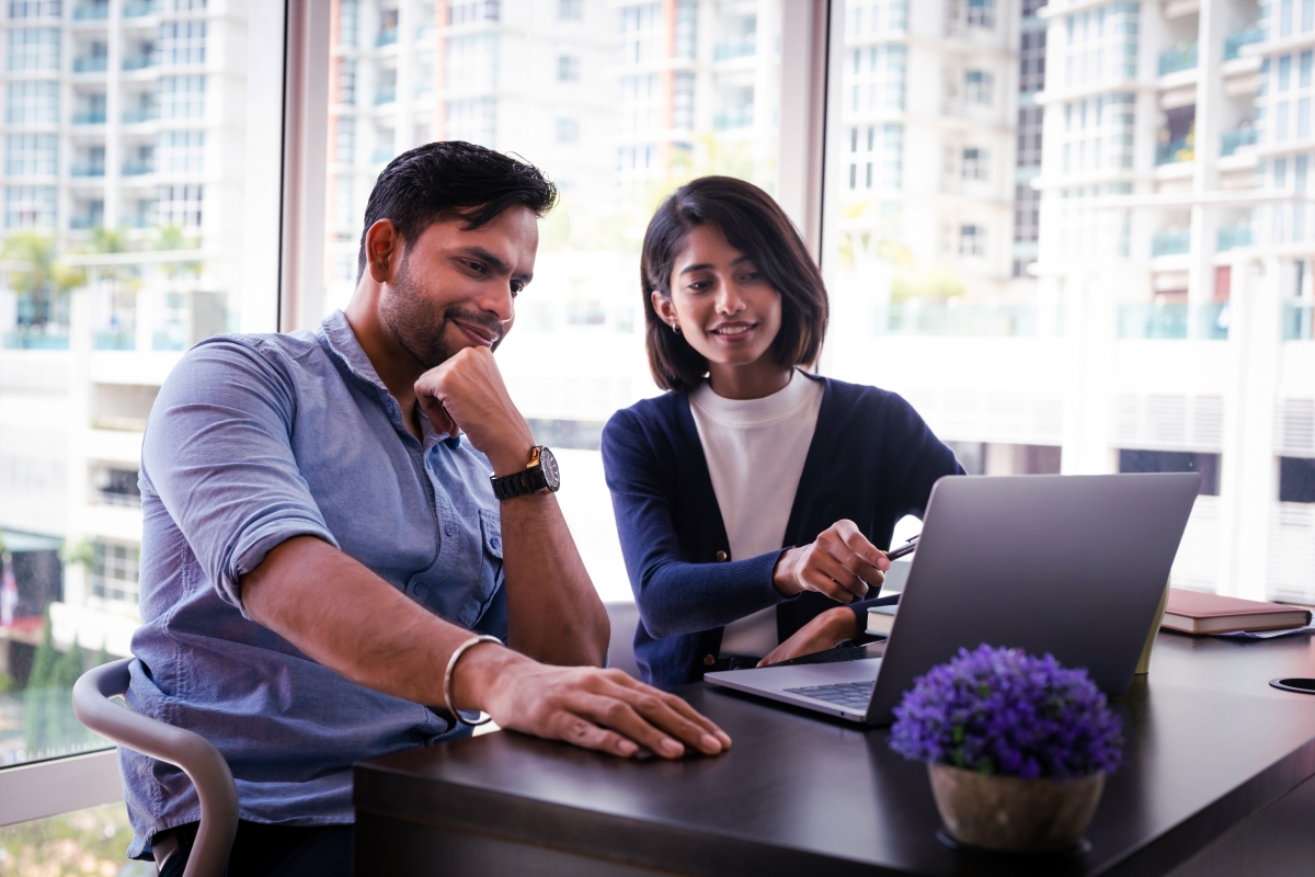 Two people working in front of a laptop