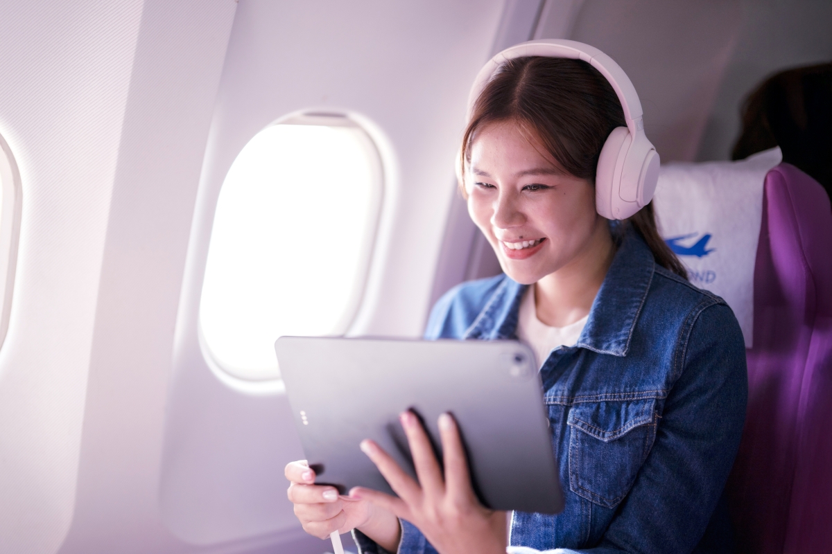 Image of a person using a tablet in an airplane.