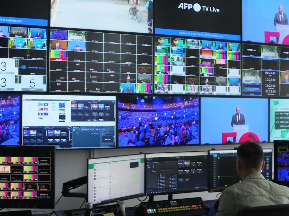 Image of a operator monitoring multiple broadcast feeds in a control room.