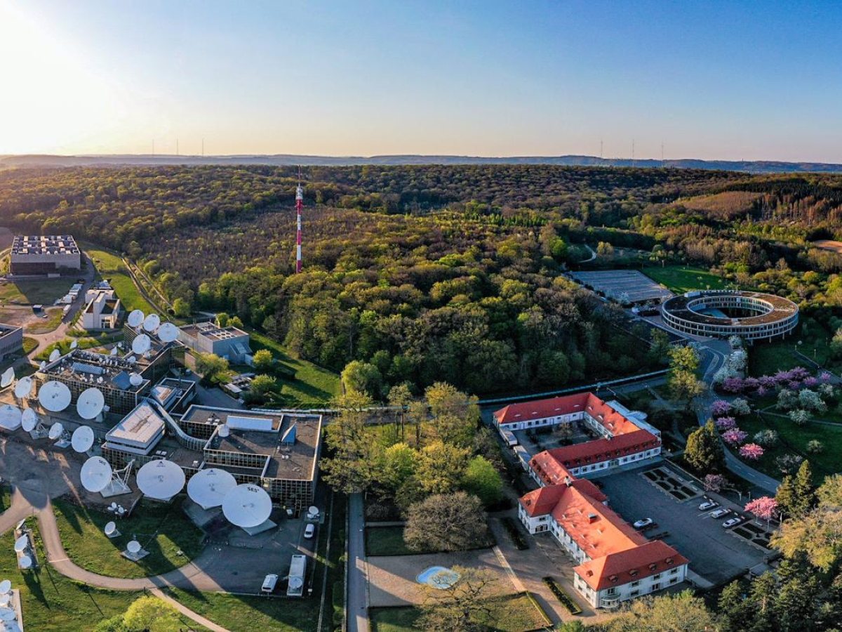 Image of Aerial view of SES Betzdorf site with satellite dishes and forest surrounding it.