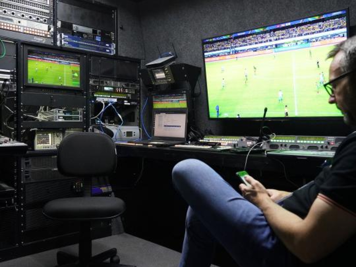 Image of a broadcast control room with multiple monitors
