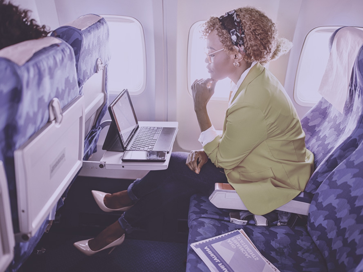Woman working on tablet on plane