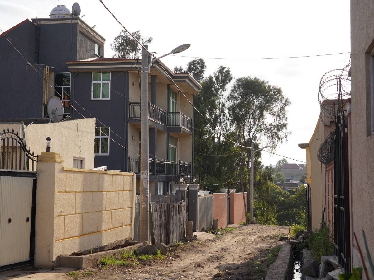 Image of a narrow residential street with houses and overhead wires.