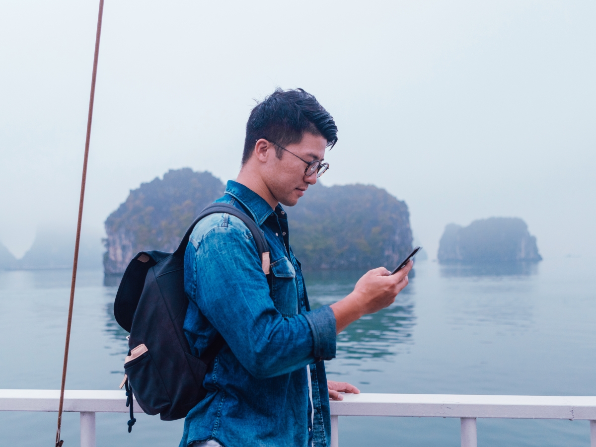Image of a Person using a phone on a ship.