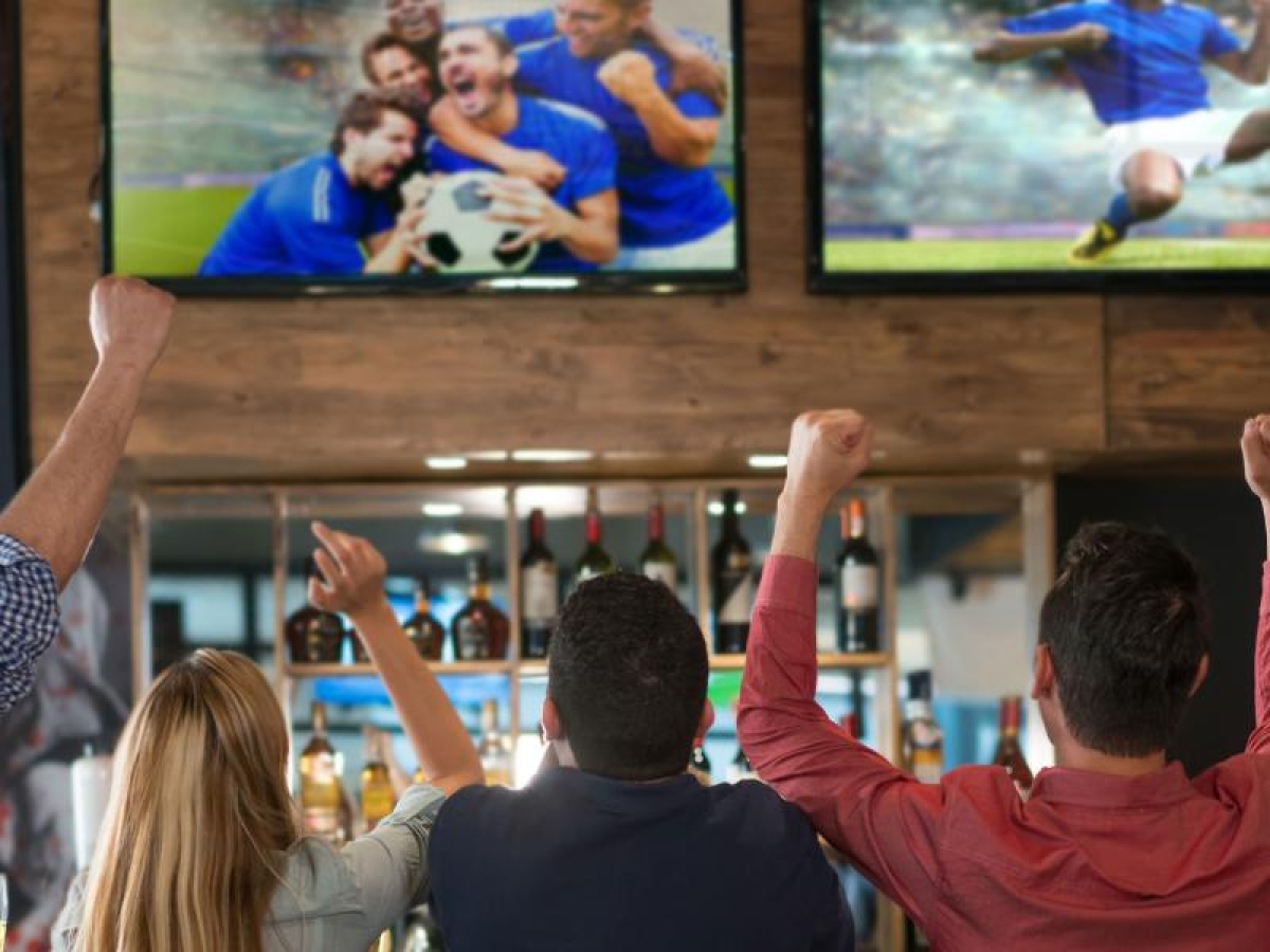 Image of a group of friends enjoying a sports game at a bar.