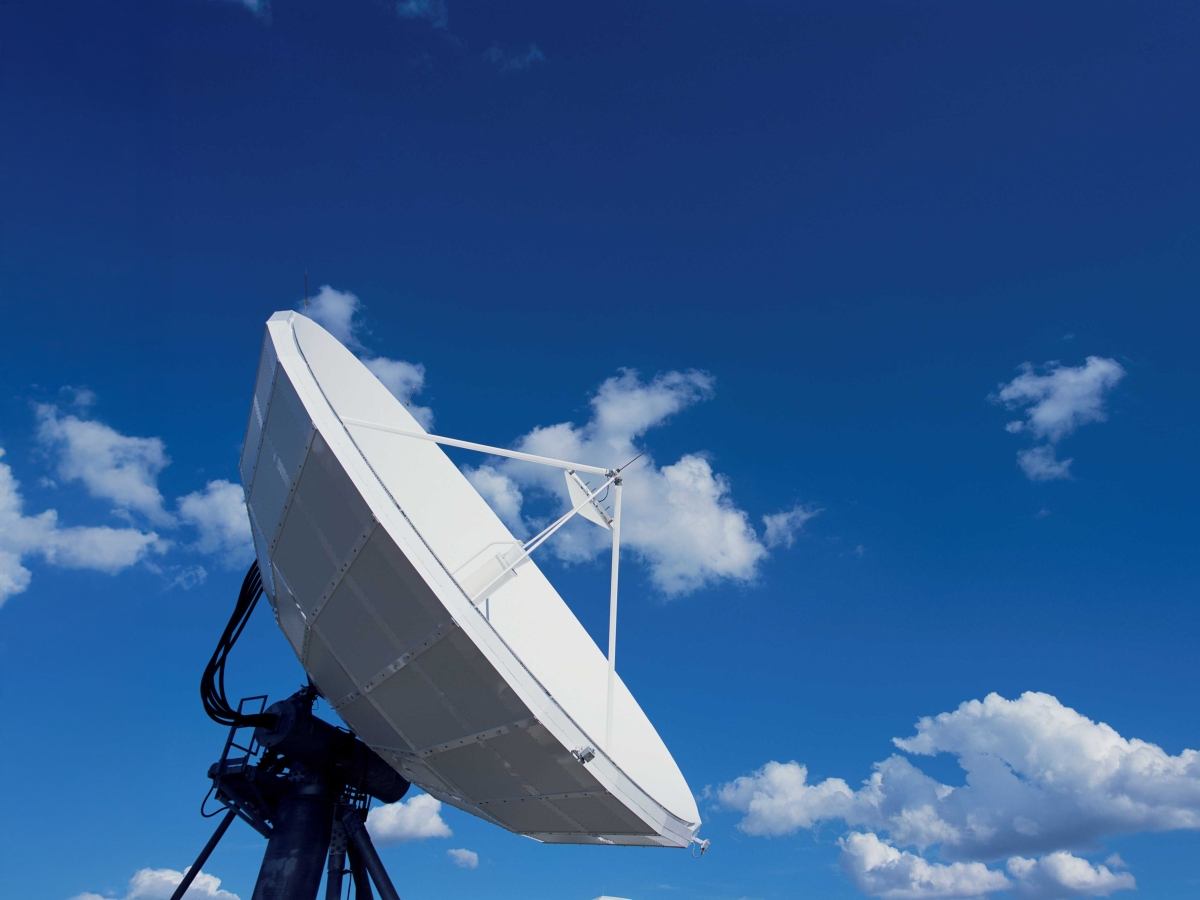 Image of an antenna dish setup with clouds in the background