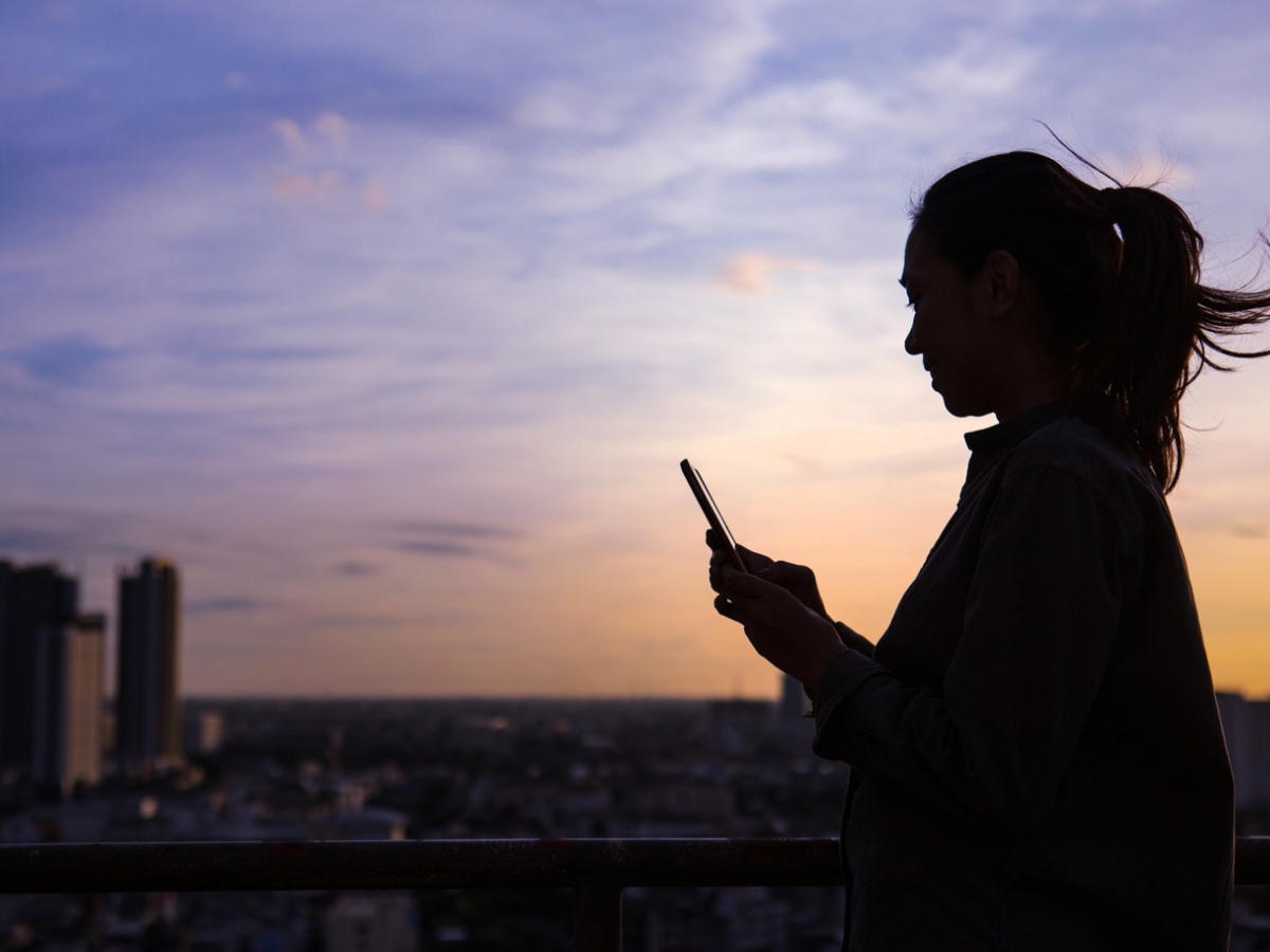Silhouette of a woman using mobile phone