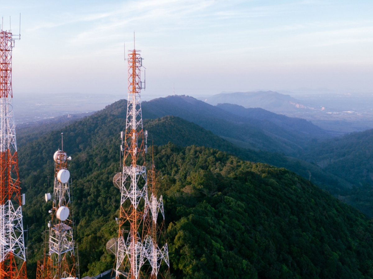 Image of multiple cellular towers with mountains in the background