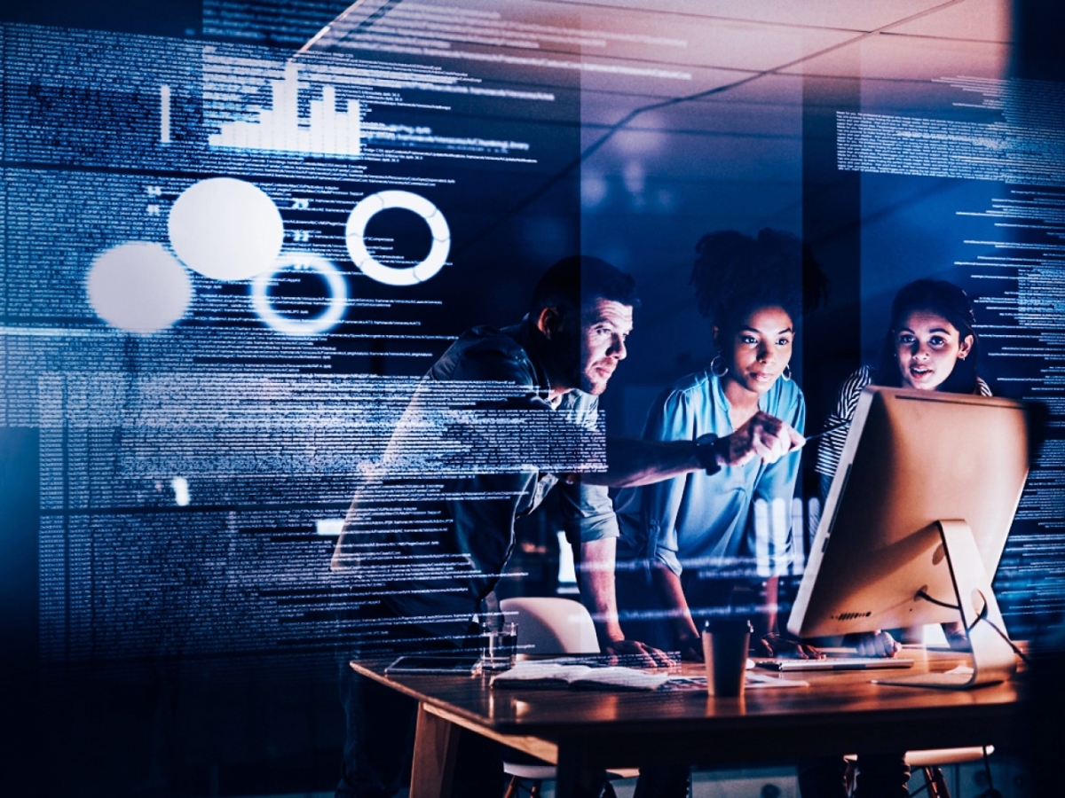 Three people looking at a monitor screen