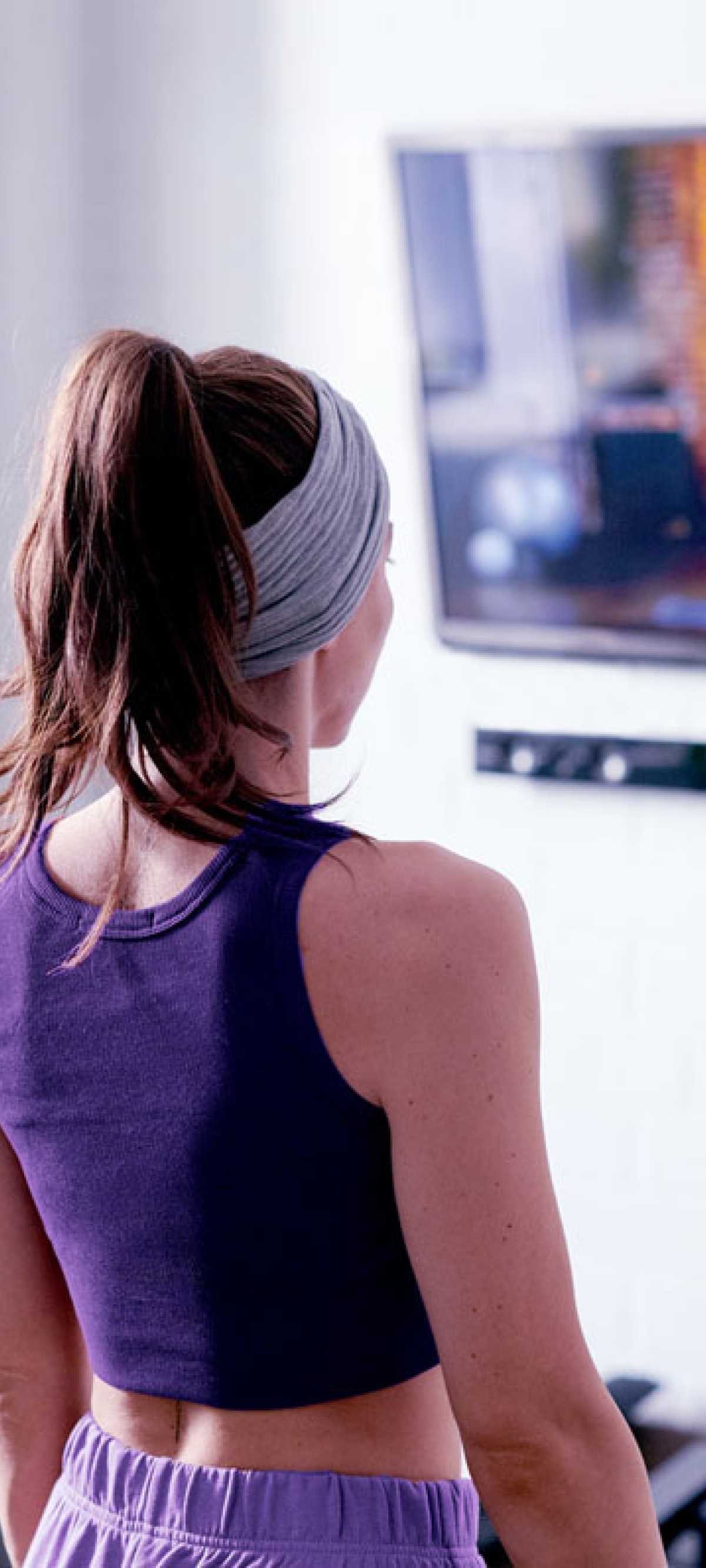 Person following an exercise video on a TV at home.